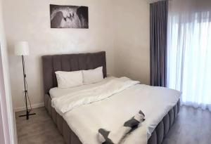 a bedroom with a large bed with white sheets at Bright Gray Нові затишні апартаменти біля центру in Ternopilʼ
