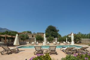a pool with chairs and tables and umbrellas at Villa Andromeda Fres in Frés