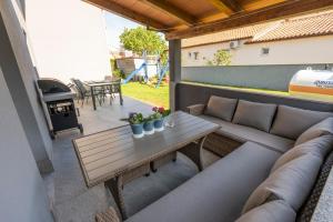 patio z kanapą, stołem i sprzętem do grillowania w obiekcie Apartments LIMIA w Puli