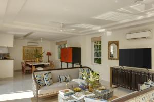 a living room with a couch and a tv at Trezora 2 Luxury 4BHK Villa with Pool in Assagaon in Goa