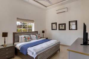 a bedroom with a bed and a television in it at Trezora 2 Luxury 4BHK Villa with Pool in Assagaon in Goa +74 photos