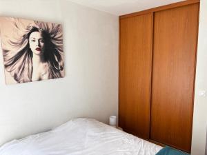 a bedroom with a bed and a wooden cabinet at T2 Cosy avec jardin Barcares Village in Le Barcarès