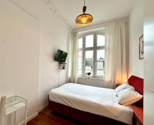 a small bedroom with a bed and a window at Pokoje na Monte Cassino 26 in Sopot