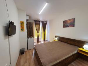 a bedroom with a large bed and a flat screen tv at Neptun-Yellow in Primorsko