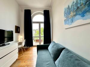 a living room with a couch and a tv at Pokoje na Monte Cassino 26 in Sopot