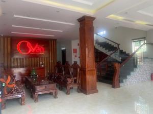 a living room with a staircase and a red neon sign at Ovan New Beach Hotel in Dong Hoi
