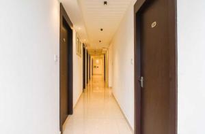 a hallway with a long corridor with white walls and ceilings at Hotel O Kalikapur Haltu in Kolkata