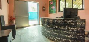 a room with a counter with a television on it at Hotel O Kalikapur Haltu in Kolkata +6 photos