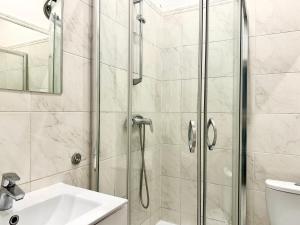 a bathroom with a shower and a sink at Pokoje na Monte Cassino 26 in Sopot