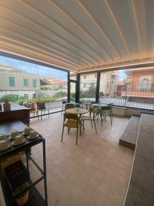 a patio with tables and chairs and a large window at Tre Gemme in Centro - Suite Azure in Pescara