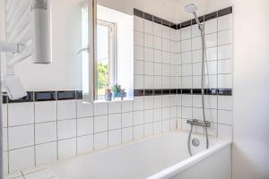 a bathroom with a tub and a window at Magnifique Maison 5 Personnes in Saint-Martin-des-Fontaines +25 photos