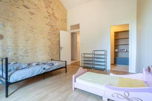 a bedroom with two beds and a brick wall at Magnifique Maison 5 Personnes in Saint-Martin-des-Fontaines