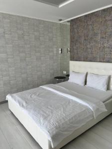 a large white bed in a bedroom with a wall at ЖК Андріївський Нова квартира в серці Тернополя in Ternopilʼ