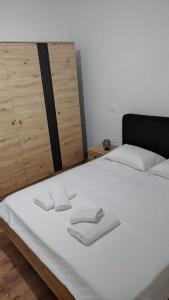 a white bed with two folded towels on it at Vila F&L in Vlorë