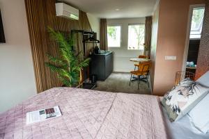 a bedroom with a bed and a plant in a room at Boetiekhotel Het Huis in Fluitenberg