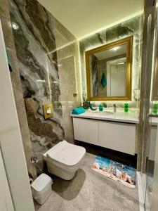 Un baño con inodoro, lavabo y espejo. en Cleopatra Beach Luxury, en Alanya 30 fotos más