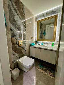 Un baño con inodoro, lavabo y espejo. en Cleopatra Beach Luxury, en Alanya