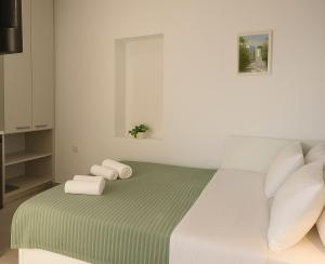 a white bedroom with a bed with towels on it at Yalos Tiny Studio - 5 mins to Elafonisi beach in Agios Padeleimon