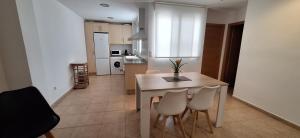 a kitchen and dining room with a table and chairs at Apartamento Cervantes in Benetúser