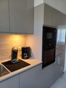 a kitchen with a counter with a microwave and a refrigerator at Cosy -confort appartment in Antwerp
