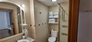 a bathroom with a toilet and a sink and a mirror at Apartamento Cervantes in Benetúser +9 photos