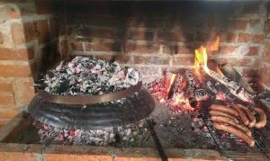 a fireplace with a bunch of hot dogs and flames at Rafting Campsite Stari Dud in Foča
