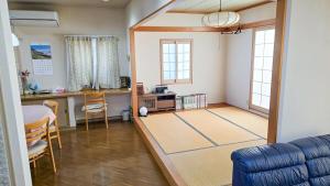 a living room with a table and a blue couch at DynaBase Iwate 81 in Hachimantai