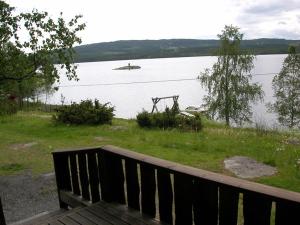 a bench sitting next to a body of water at Hagali by Norgesbooking - cabin by the lake Næra, close to Sjusjøen in Ringsaker
