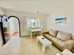 una sala de estar con un sofá y una mesa en SAN JAIME 5 by SOM Menorca, en Son Bou