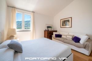 a white bedroom with a bed and a couch at Suite Ulivo by Villa Melograno, Pool, AC, Parking in Santa Margherita Ligure