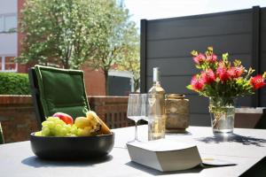 a bowl of fruit on a table with a bottle of wine at Insel-Juwel im Lindenhof in Wangerooge +14 photos