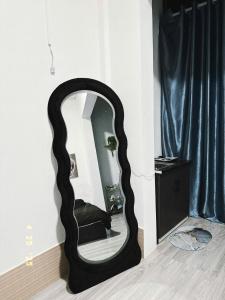 カントーにあるMie Homestay 3 Cần Thơの部屋の壁に掛かっている黒い楕円形の鏡