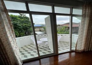 an open door to a balcony with a table and chairs at RQ THEVA Heritique Baan Praya Dinsor Road in Bangkok