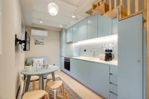 une cuisine avec des placards blancs et une petite table dans l'établissement Figueirôa Four Houses by DA'Home, à Porto