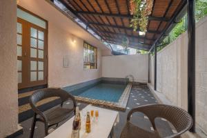 una piscina en medio de un patio con sillas en Echor Avontade Pool Villas Anjuna Goa, en Anjuna