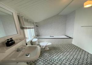 a bathroom with a sink and a toilet at RQ THEVA Heritique Baan Praya Dinsor Road in Bangkok
