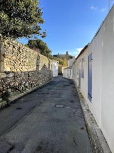 an empty street next to a stone wall at Maison typique au cœur du centre ville in Saint-Gilles-Croix-de-Vie