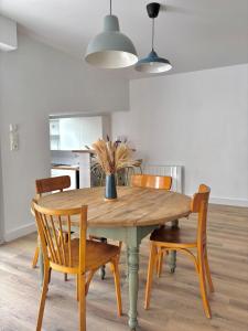 a dining room table with chairs and a vase on it at Maison typique au cœur du centre ville in Saint-Gilles-Croix-de-Vie