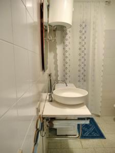 a white bathroom with a sink and a shower curtain at Casa Antony in San Teodoro