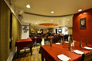 a dining room with tables and chairs in a restaurant at Hotel Rajawas in Dibrugarh