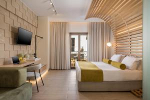 a hotel room with a large bed and a desk at Agave Suites in Chania Town