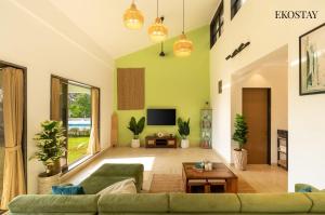 a living room with a couch and a table at EKOSTAY - White Lotus in Karjat