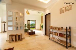 a living room with a book shelf and a couch at EKOSTAY - White Lotus in Karjat