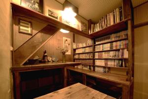 una biblioteca con un estante lleno de libros en Guesthouse Yululu, en Kioto