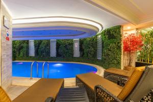 a swimming pool in a room with a wall of plants at Askoc Hotel & SPA in Istanbul