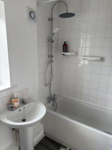 a bathroom with a tub and a sink and a shower at Sunderland Castle Free Parking in Sunderland