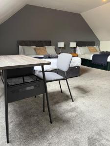 a bedroom with two beds and a table with a chair at Sunderland Castle Free Parking in Sunderland