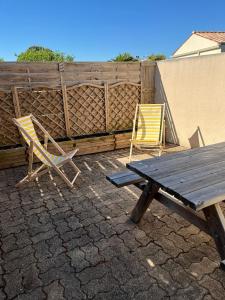 two chairs and a picnic table on a patio at Studio pour 2 personnes à Tonnay Charente in Tonnay-Charente +9 photos
