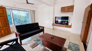 a living room with a couch and a tv at Chippy Villa No 5 Tiruchirappalli in Tiruchchirāppalli