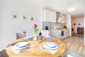 a kitchen and dining room with a wooden table and chairs at Terrassenwohnung "Haffromantik" in Garz